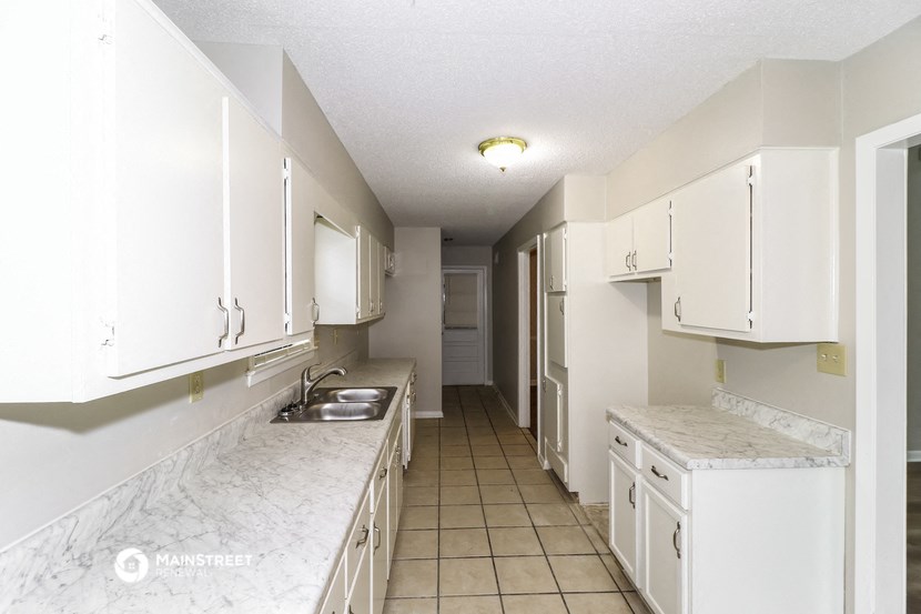 a kitchen with white cabinets and marble counter tops and a sink