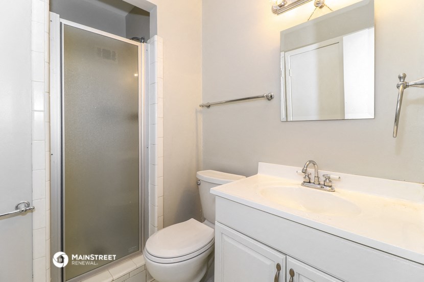 a white bathroom with a shower toilet and sink