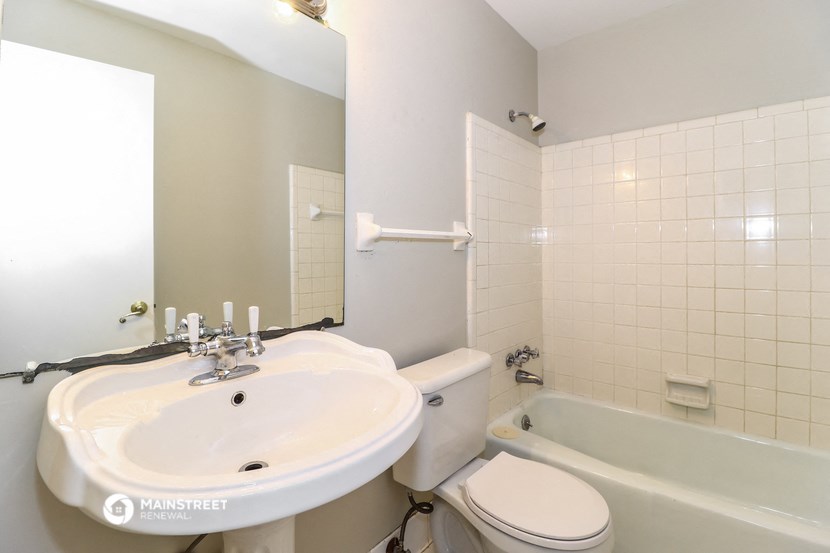 a white bathroom with a sink toilet and bath tub