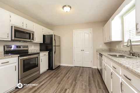 a kitchen with white cabinets and stainless steel appliances