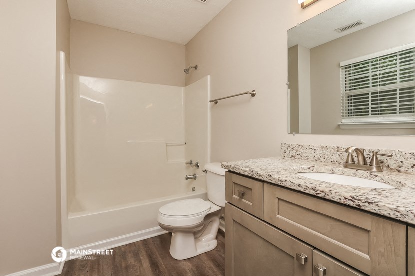 a bathroom with a shower and a sink and a toilet