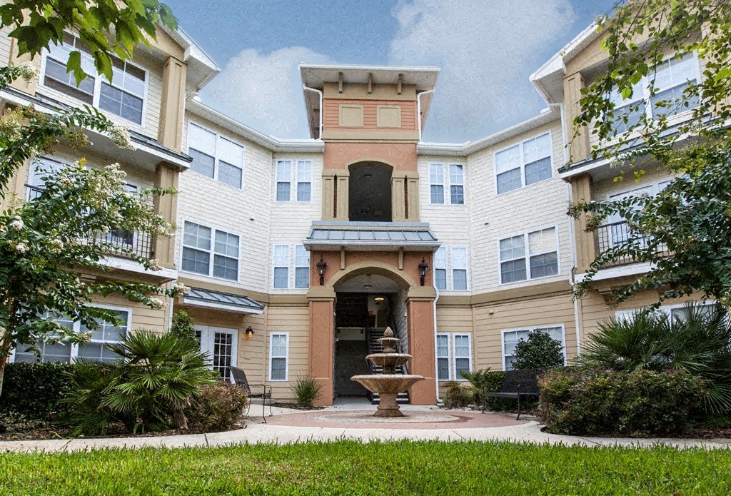 a courtyard with a fountain in front of an apartment building