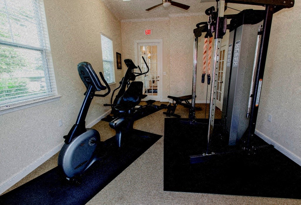 a gym with exercise equipment in a room with a window