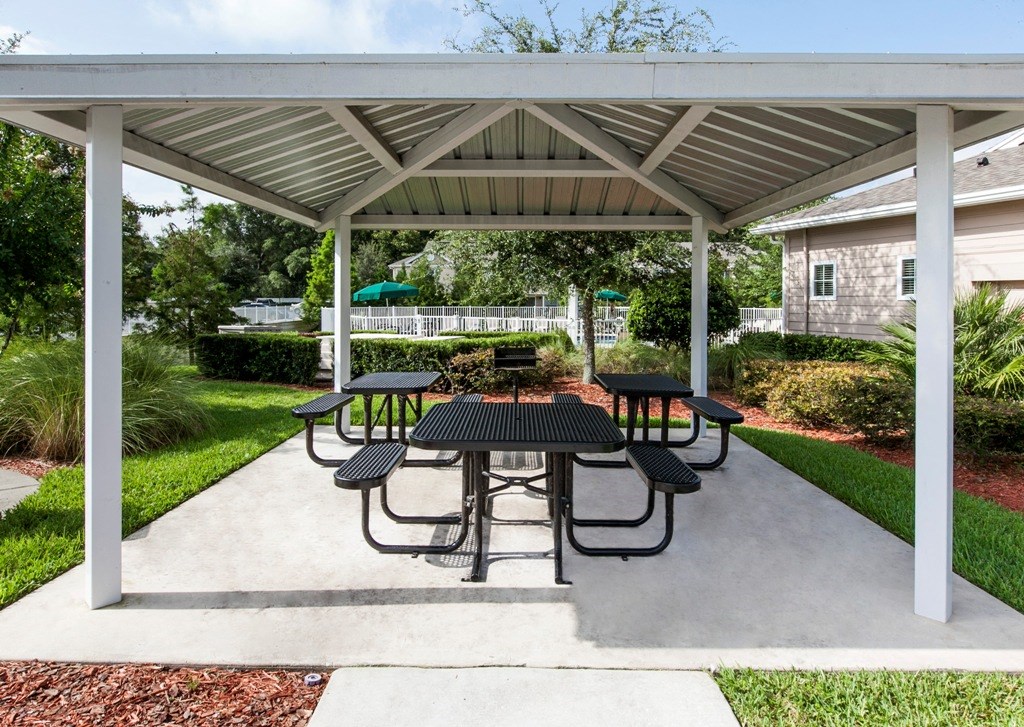 a patio with a table and chairs under a pavilion