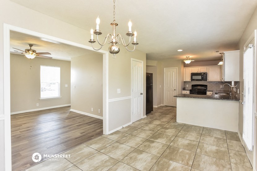 an empty kitchen and living room with a chandelier