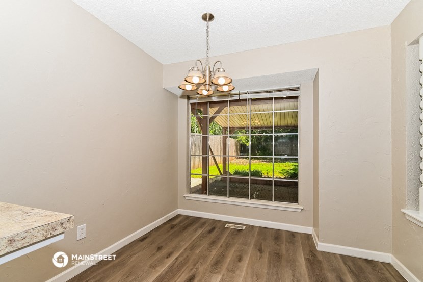 a living room with a window and a table and a chandelier