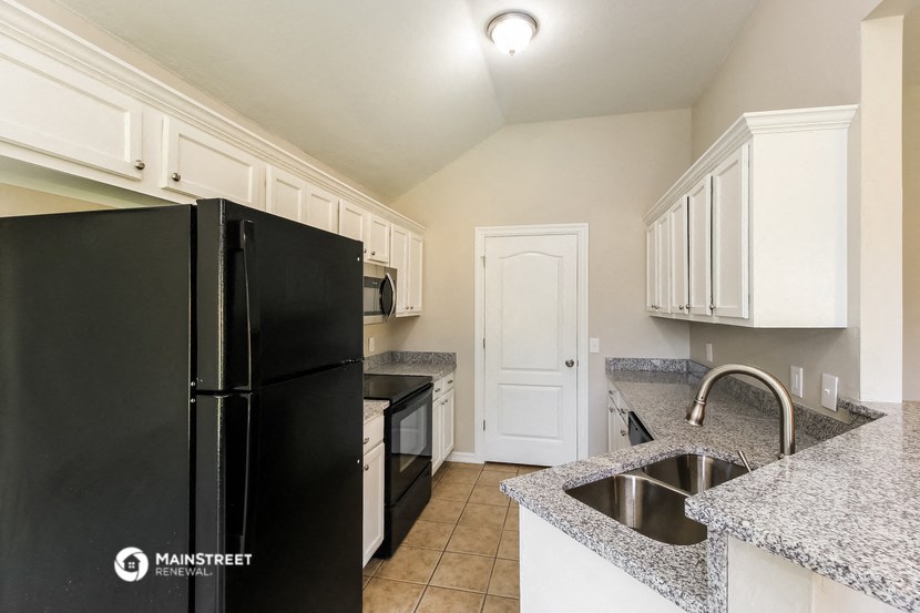 a kitchen with granite counter tops and black appliances