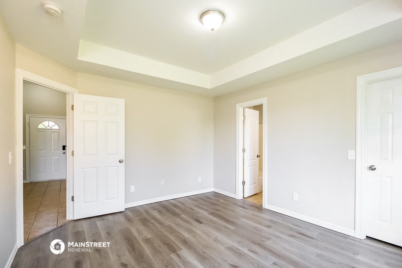 the living room of a new home with white walls and wood floors