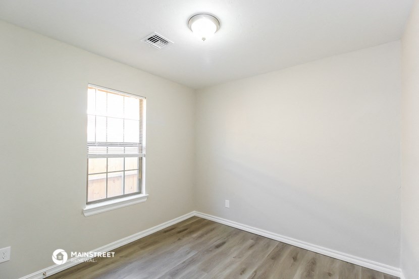the living room of a new home with wood flooring and a window