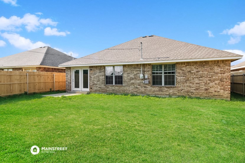 a brick house with a yard and a wooden fence