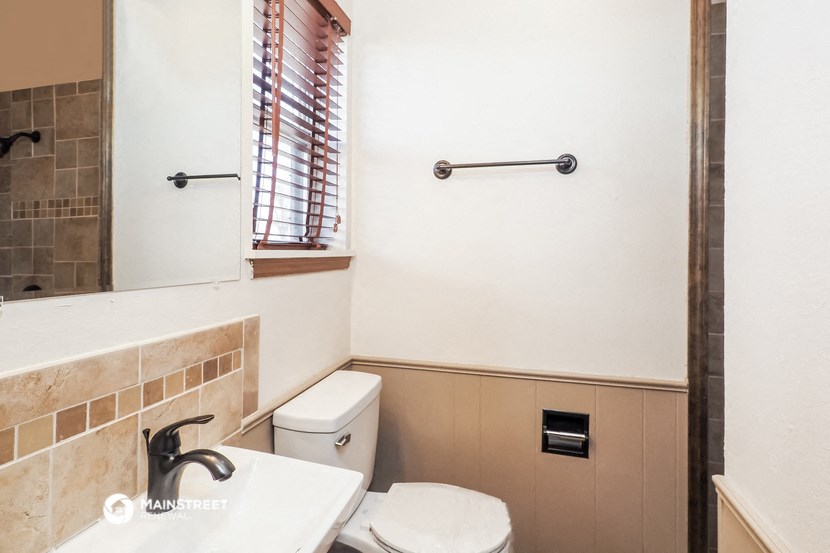 a bathroom with a toilet and a sink and a mirror