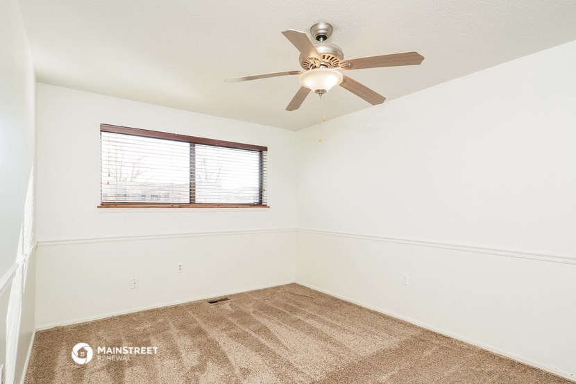 a bedroom with a ceiling fan and a window