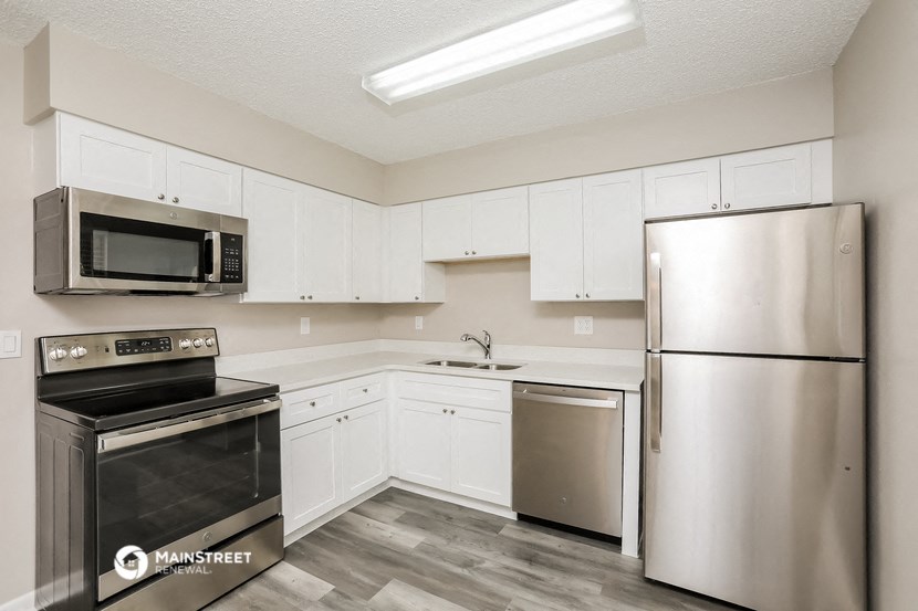 a kitchen with stainless steel appliances and white cabinets
