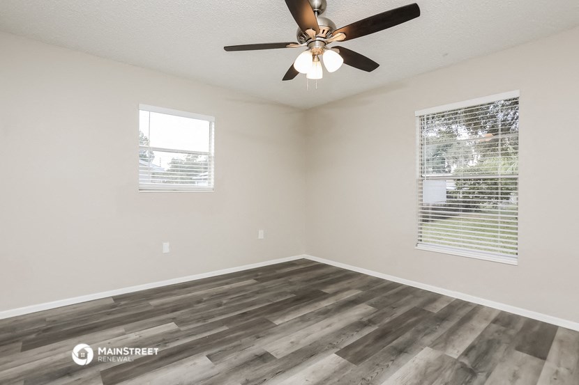 the living room of our studio apartment atrium with wood floors and a ceiling fan