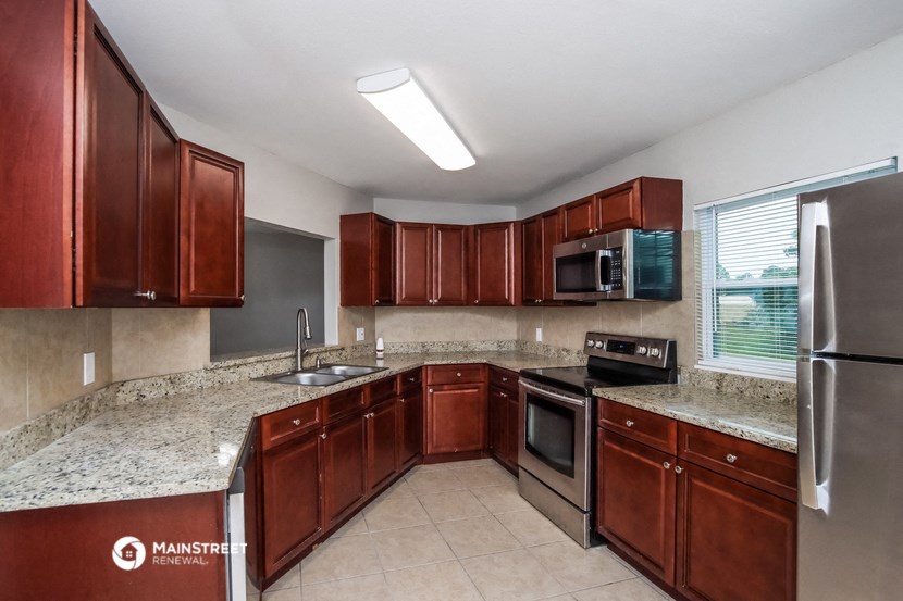 a kitchen with wooden cabinets and granite counter tops and stainless steel appliances