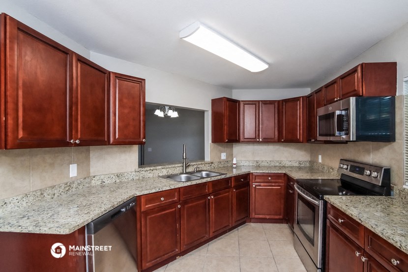a kitchen with granite counter tops and wooden cabinets