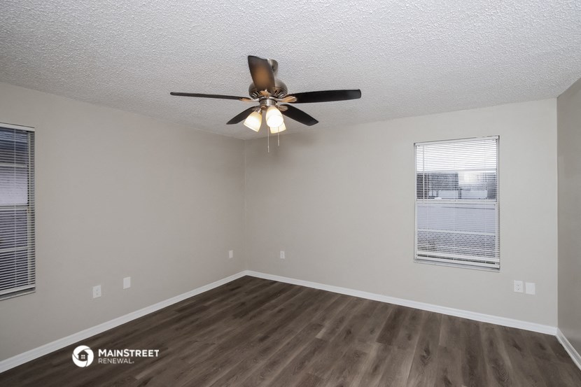 a living room with a ceiling fan and a window