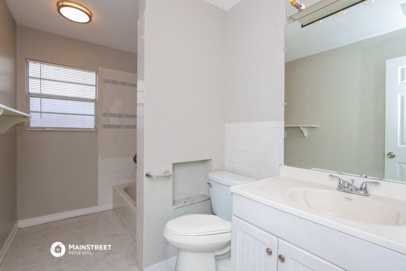 a bathroom with a toilet and a sink and a mirror