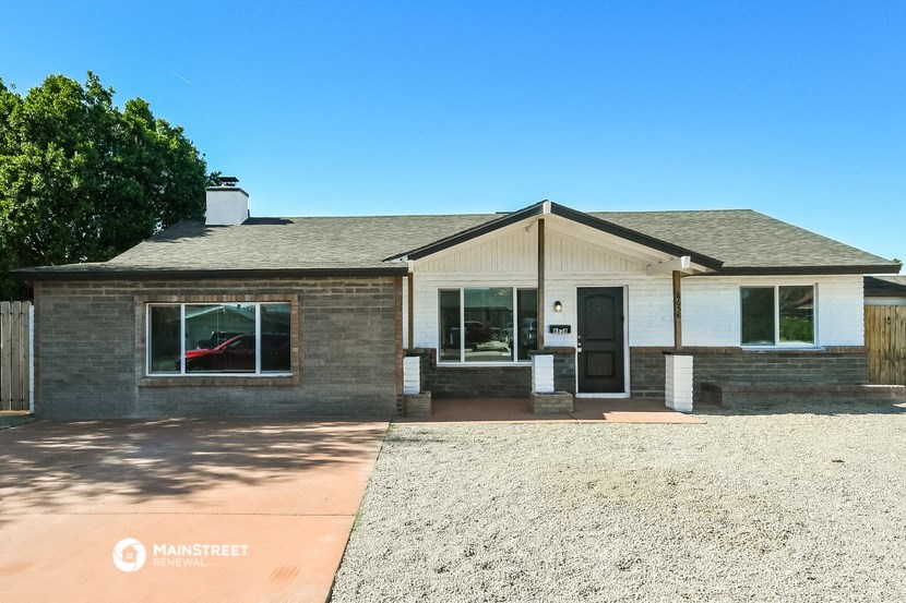 the front of a brick house with a gravel driveway