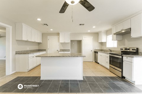 a large kitchen with white cabinets and a counter top