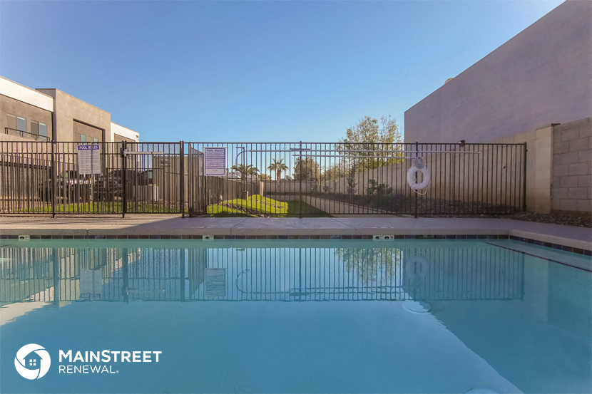 a swimming pool with a fence around it and a building in the background