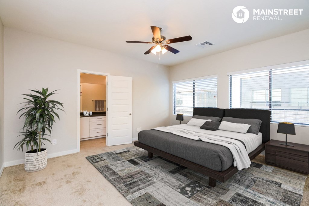 a bedroom with a bed and a ceiling fan