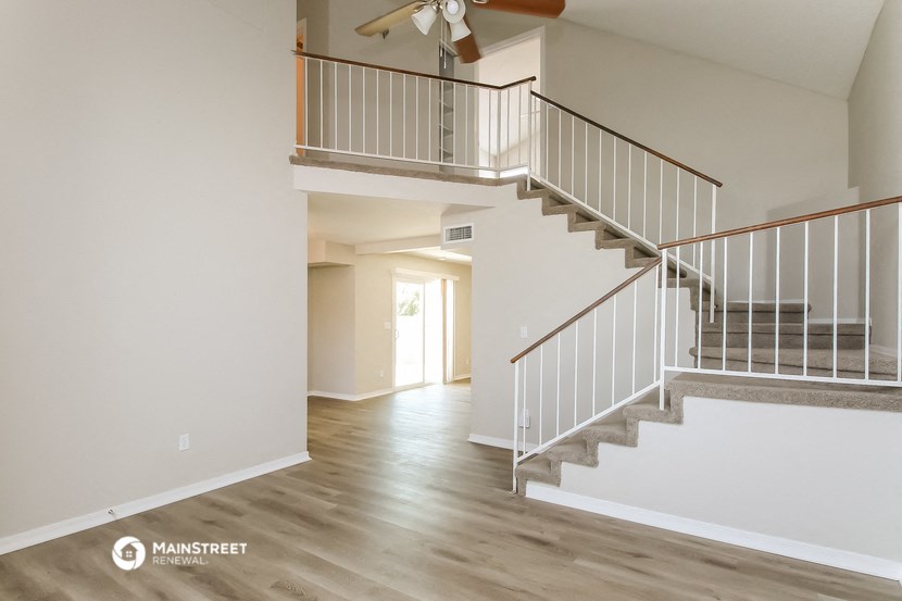 the upstairs of a house with stairs and a ceiling fan