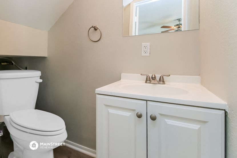 a bathroom with a sink toilet and a mirror
