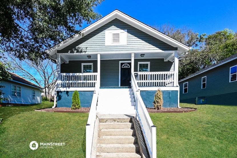 a blue house with a porch and stairs