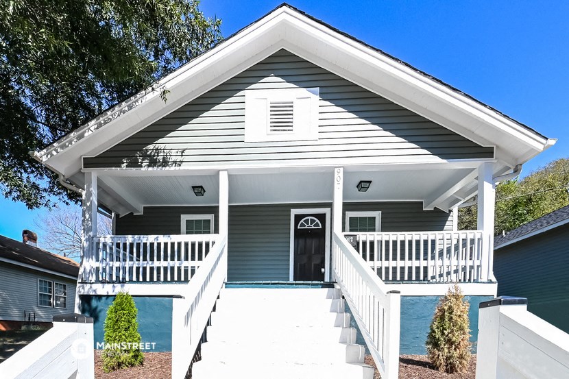 a house with a white porch and a black door
