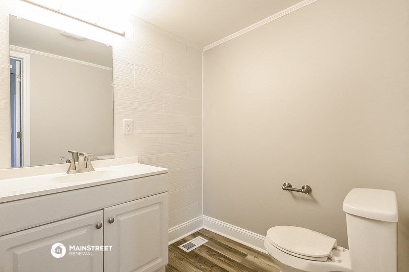 a white bathroom with a toilet sink and mirror