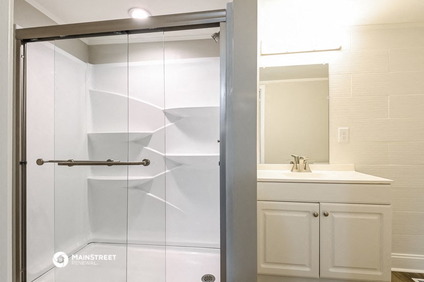 a white bathroom with a shower and a sink