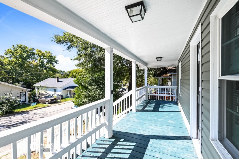 the front porch of a house with a porch swing