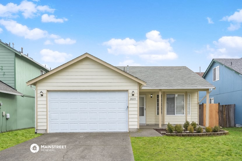 a white house with a white garage door and a lawn