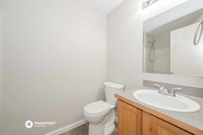 a bathroom with a toilet and a sink and a mirror
