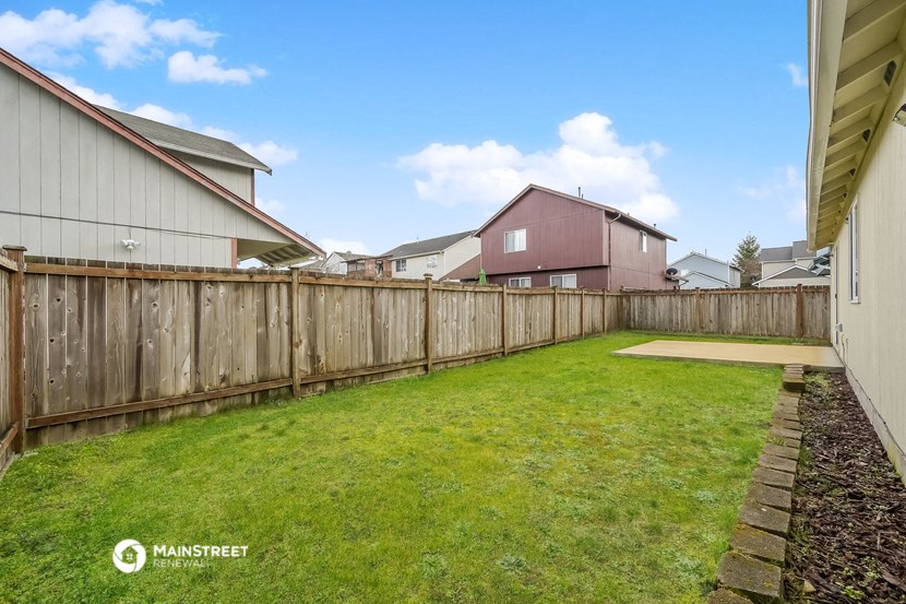 a backyard with a wooden fence and a house