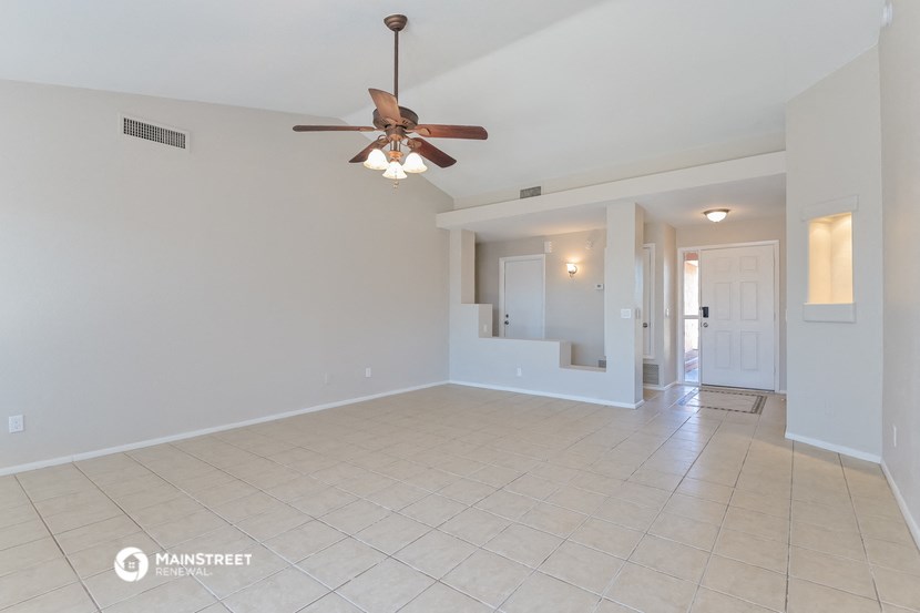 a empty living room with a ceiling fan