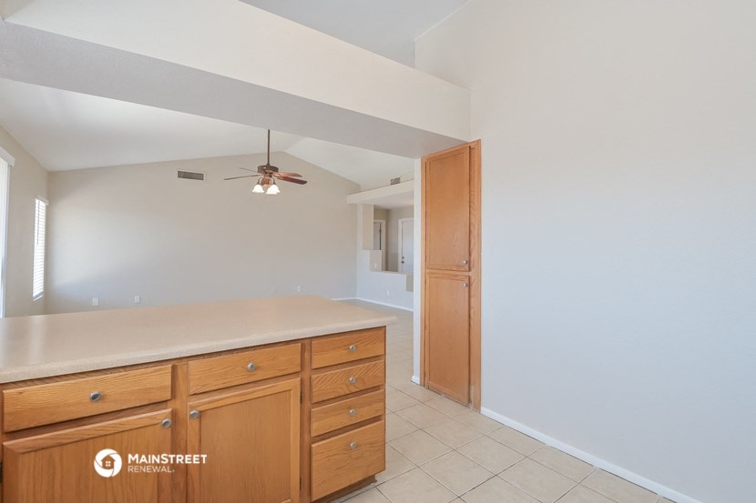 a kitchen with a counter top and a ceiling fan