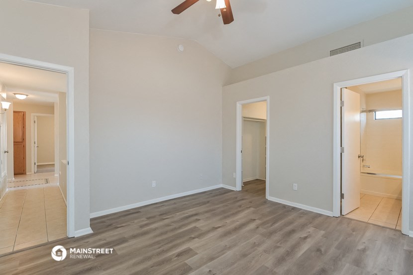 an empty living room with wood flooring and white walls