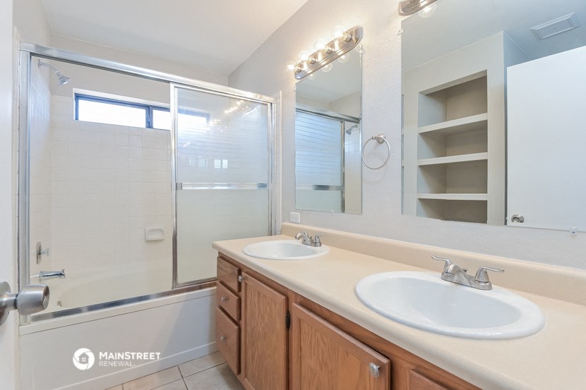 a bathroom with two sinks and a shower