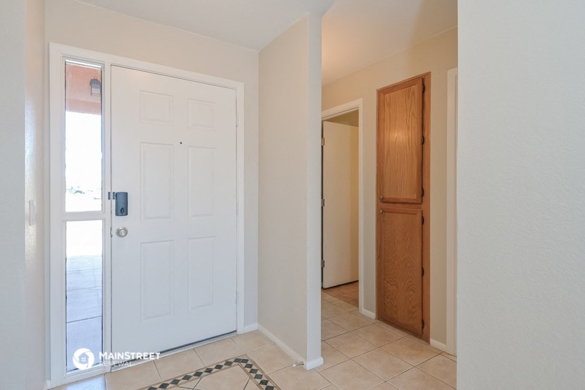 a hallway with a white door and a door to a closet