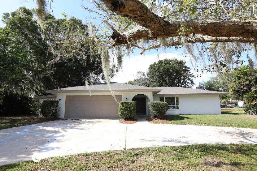 a white house with a tree in front of it
