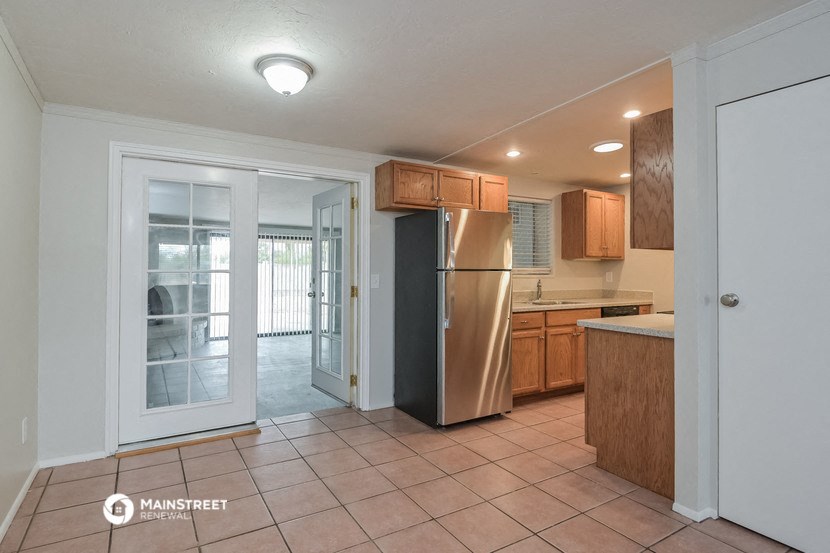 a kitchen with a stainless steel refrigerator and a door to a patio