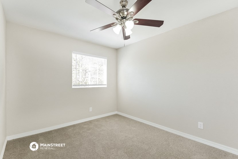 a bedroom with a ceiling fan and a window