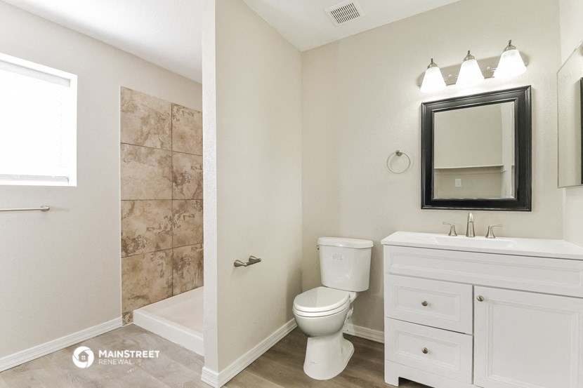 a white bathroom with a shower toilet and sink