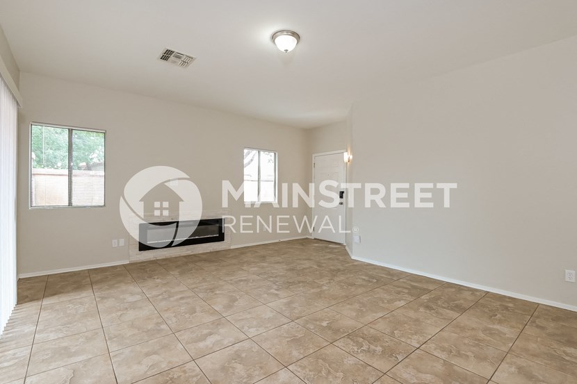 a large living room with tile flooring and a window