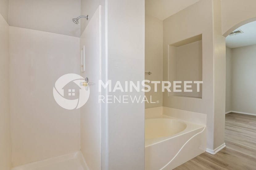 a renovated bathroom with a tub and a mirror