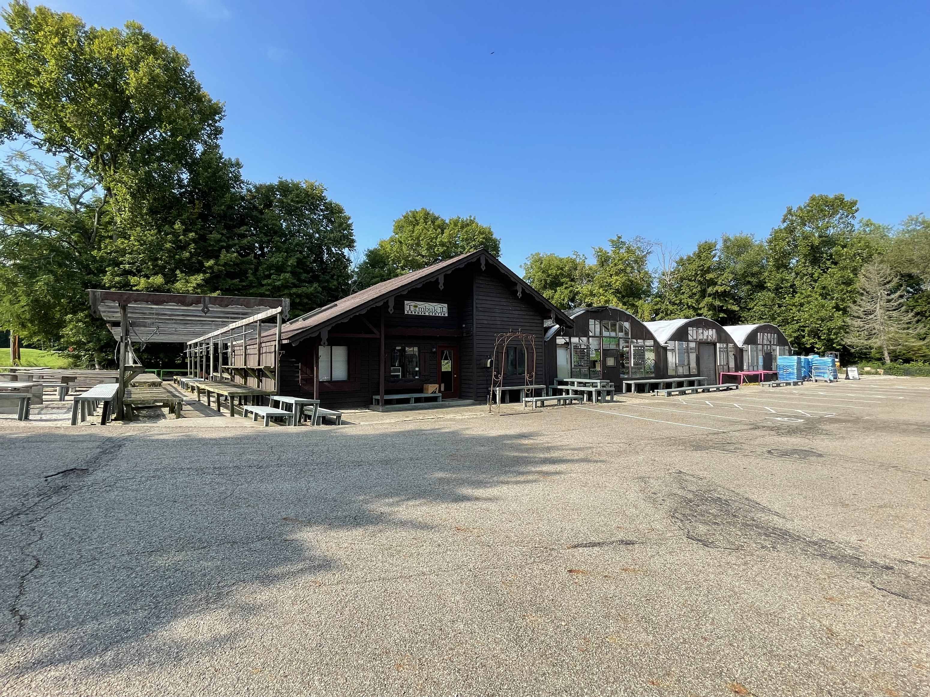 a parking lot in front of a building with benches and tables