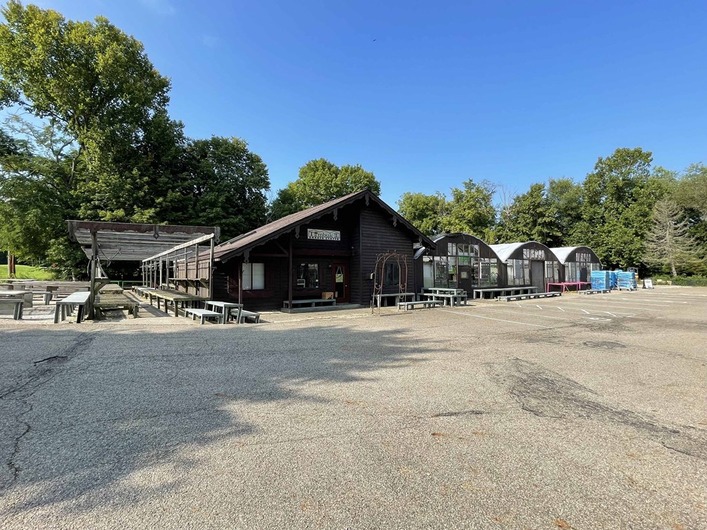 a parking lot in front of a building with benches and tables