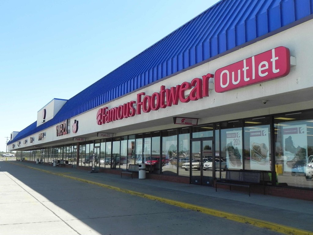the outside of a roundabout outlet store with cars in the window